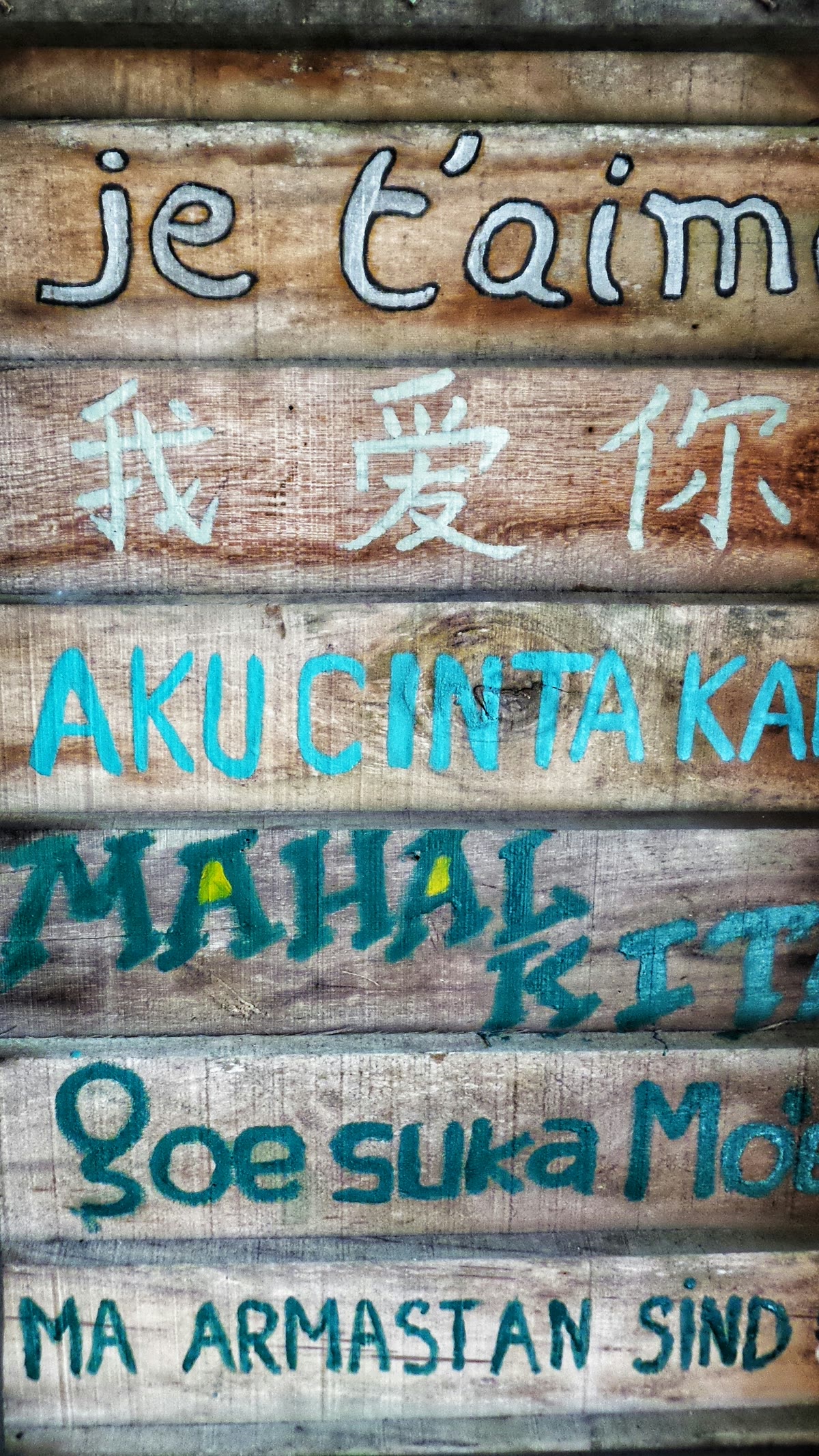 Wooden posts with words written in different languages